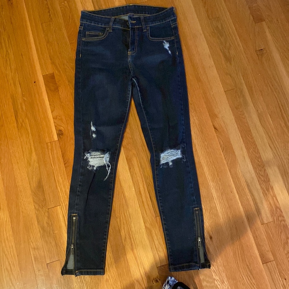 Size 26 Carmar denim jeans with rips on knees and zippers up calf. Skinny